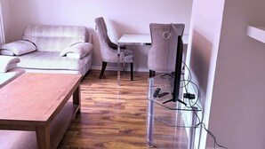 Un soggiorno moderno con un divano, un tavolino da caffè e un mobile TV con ripiano in vetro.