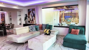 Een moderne woonkamer met een modulaire bank, een marmeren salontafel en een groot raam met uitzicht op een stadsbeeld.