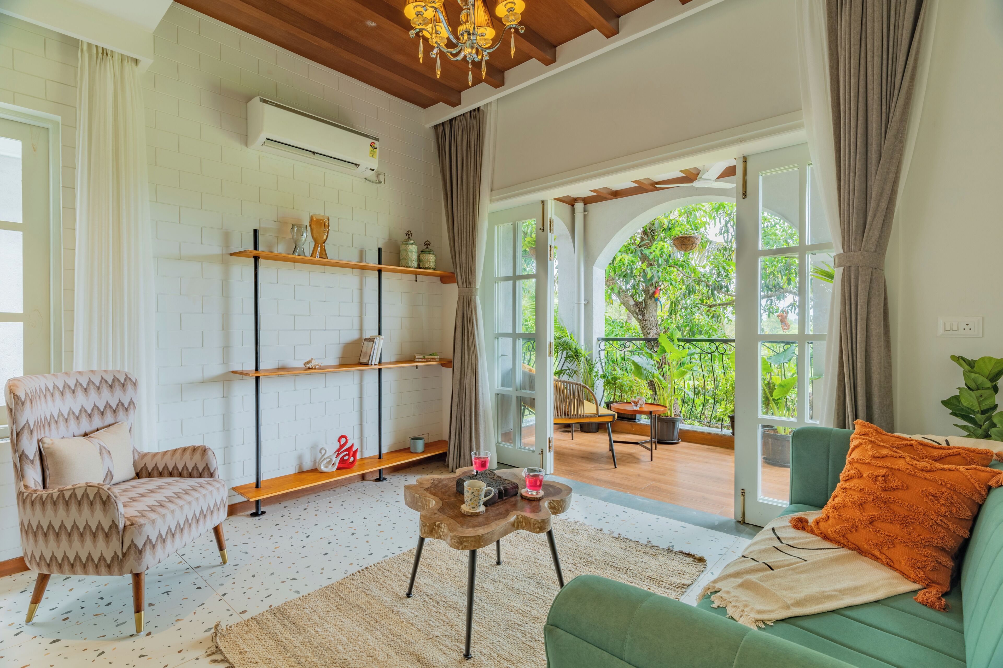 A living room with a sofa, armchair, coffee table, and shelves.