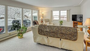 A living room with a sofa, a chair, a TV, a lamp, and a plant. - 2 Mi to Downtown Billings! Charming Family Home (Billings)