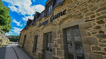 A stone building with the sign 'Coque Game' indicating a restaurant or cafe.
