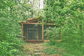 Una cabaña de madera rodeada de un bosque denso.
