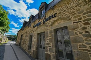 Een stenen gebouw met het bord 'Coque Game', dat een restaurant of café aanduidt.
