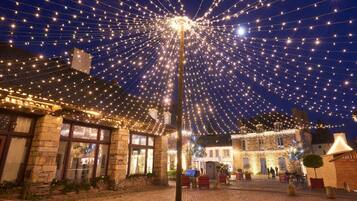 Un edificio histórico con paredes de piedra y arquitectura tradicional, decorado con luces colgantes.