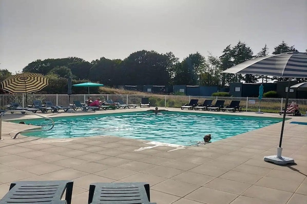 A swimming pool with lounge chairs and umbrellas.
