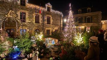 Un edificio de piedra con una decoración navideña que presenta un nacimiento y árboles iluminados.