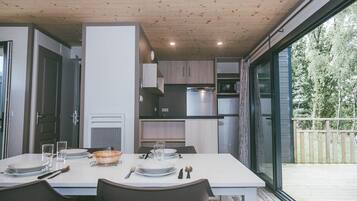 Une cuisine moderne dotée d’appareils électroménagers intégrés et d’un coin repas avec une table mise pour deux personnes.