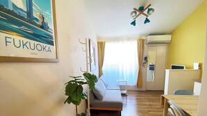 A modern living room with a sofa, a dining table, a plant, and a ceiling fan. - A quiet residential area that blends in with the local community ｜ Close to LaLaport Fukuoka ｜ Close to Fukuoka Airport ｜ Refreshing space (Morooka Hakata-ku Fukuoka city)