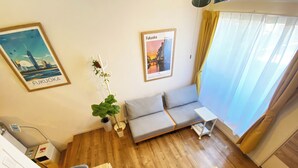 A room with a sofa, a small table, a potted plant, and two framed pictures on the wall. - A quiet residential area that blends in with the local community ｜ Close to LaLaport Fukuoka ｜ Close to Fukuoka Airport ｜ Refreshing space (Morooka Hakata-ku Fukuoka city)