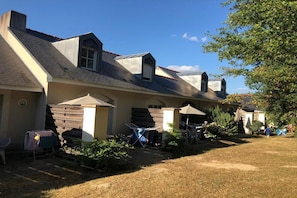 A row of houses with attached garages, a grassy yard, and a clear sky.