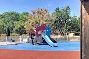Une aire de jeux avec un toboggan et des structures d’escalade.