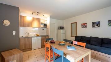 A compact living space with a kitchenette, dining area, and seating area.