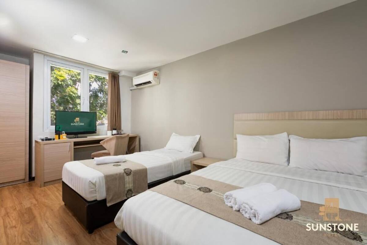 Une chambre d’hôtel avec deux lits, un bureau, une télévision et un appareil de climatisation.