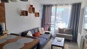 A modern living room with a sofa, a wooden dining table, and a coffee table. - La parenthese suspendu (Font-Romeu-Odeillo-Via)