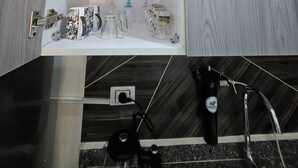 Ein Badezimmer mit Spiegel, Handtuchhalter, Waschbecken und Toilette.