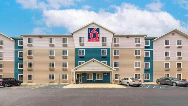 Un hotel de 6 suites con entrada principal, varios pisos y estacionamiento.