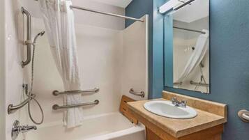 Un baño con bañera, ducha y lavamanos.