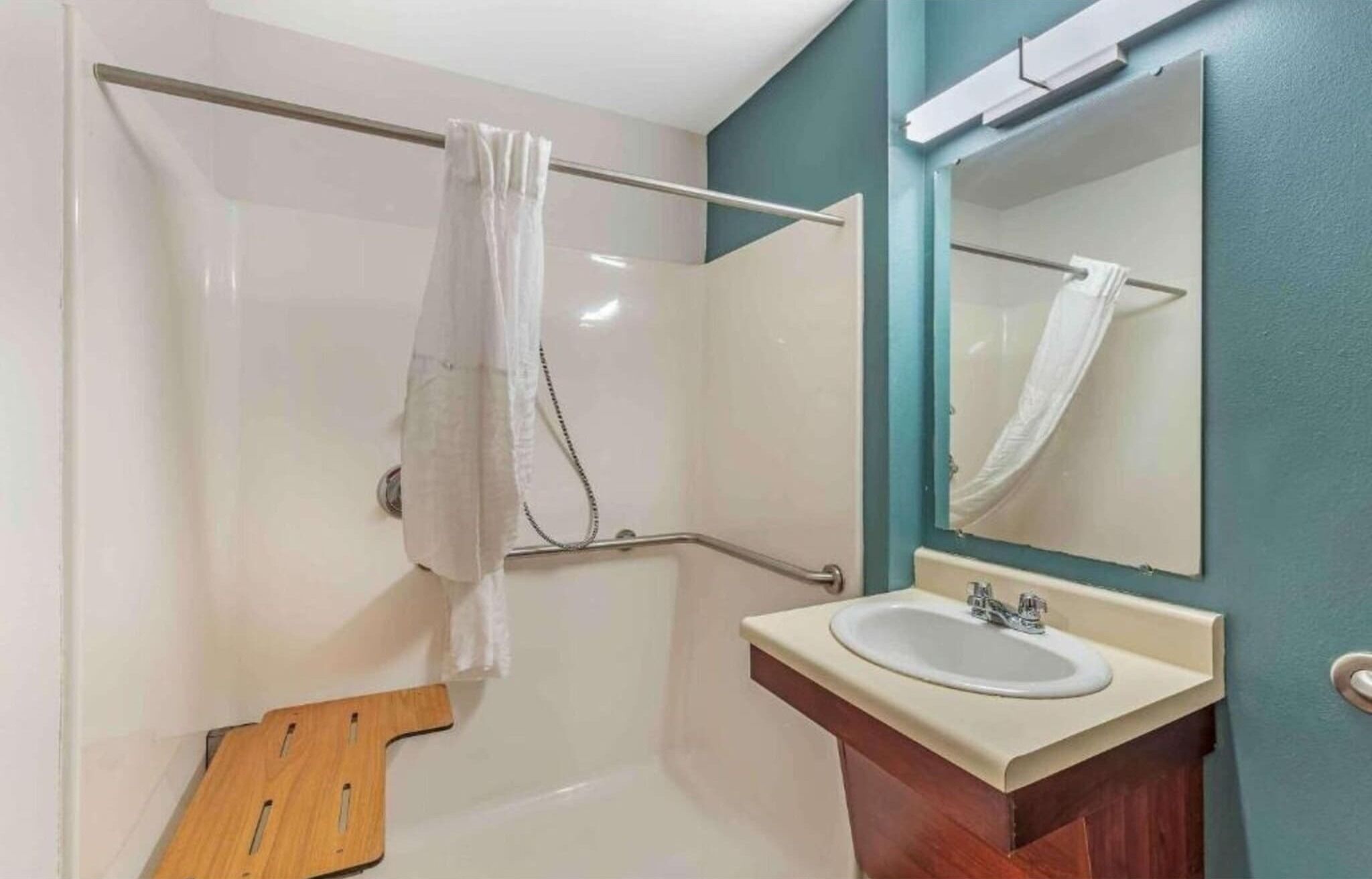 Ein Badezimmer mit Dusche, Waschbecken und Spiegel.