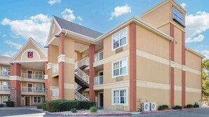 A multi-story hotel with a prominent '6' logo, balconies, and a central staircase. - 2 Full Beds | Mobil Access Tub Nsmk Kitchen (Fresno CA)