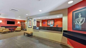 A hotel lobby with a reception desk, seating area, and a large screen. - 2 Full Beds | Mobil Access Tub Nsmk Kitchen (Fresno CA)