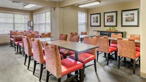 A conference room with tables and chairs, large windows with blinds, and framed pictures on the wall. - 2 Full Beds | Non-Smoking, Kitchen (Jacksonville)