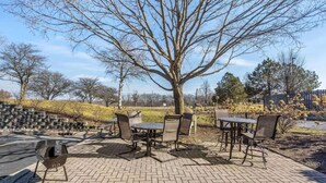 An outdoor patio with brick flooring, a grill, and a table with chairs. - 1 King Bed | Non-Smoking, Kitchen, Shower (Chicago)
