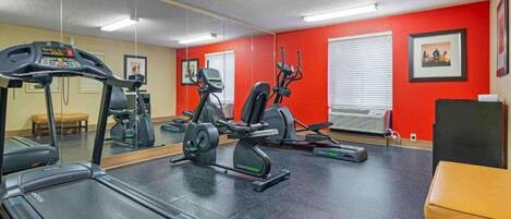 A gym with a treadmill, elliptical, and stationary bike.