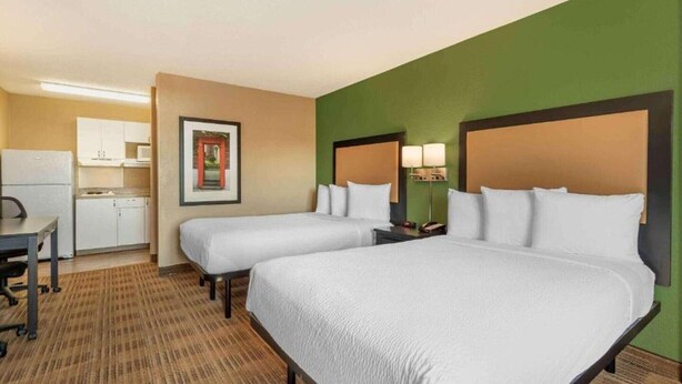 A hotel room with two beds, a kitchenette, a dining table, and a framed picture on the wall. - 2 Full Beds | Non-Smoking, Kitchen (Germantown)