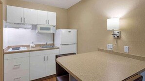 A small kitchenette with white cabinets, a microwave, a refrigerator, a sink, and a countertop. - 2 Full Beds | Non-Smoking, Kitchen (Germantown)