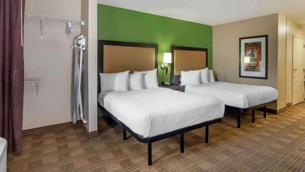 A hotel room with two beds, a shower, a green accent wall, and a framed picture on the wall. - 2 Queen Beds |Non-Smoking, Kitchen (Germantown)