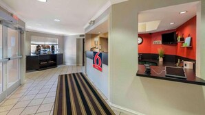 A hotel lobby with a reception desk, a coffee station, and a kitchen area. - 2 Full Beds | Mobil Access Tub Nsmk Kitchen (Minneapolis MN)