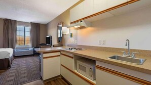 A compact hotel room with a kitchenette, a bed, a television, and a window with curtains. - 2 Queen Beds |Non- Smoking, Kitchen (Minneapolis MN)