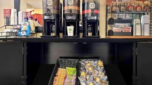 A coffee station with three coffee makers, a tray of snacks, and a display of instant coffee and other beverages. - 1 King Bed | Non-Smoking, Kitchen, Shower (Minneapolis MN)
