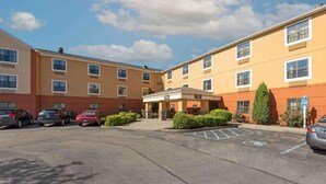 A multi-story hotel with a parking lot, a covered entrance, and a handicap-accessible sign.
