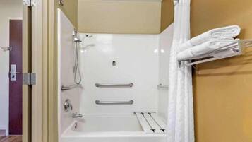 A shower with a glass door, a towel rack, and a shower control panel.