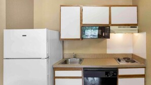 Una cocina compacta equipada con refrigerador, microondas, pileta, estufa y lavavajillas.