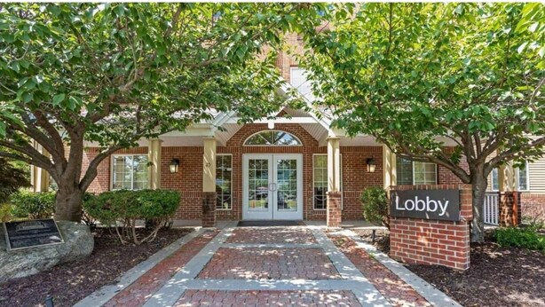 A brick building with a sign reading 'Lobby' in front.