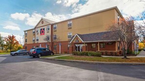 Un hôtel à plusieurs étages, reconnaissable à son grand panneau indiquant le chiffre « 6 », à son entrée marquée de l’inscription « LADY » et à son parking rempli de voitures.