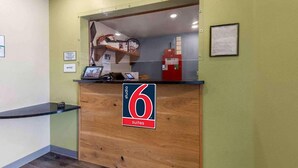 A reception desk with a sign indicating '6 suites' and a counter with a computer monitor. - 2 Full Beds | Smoking, Kitchen (Oklahoma City OK)
