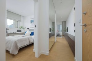 Een moderne hotelkamer met een bed, nachtkastje en een grote spiegel.