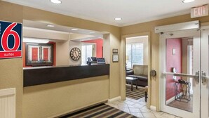 A hotel lobby with a reception desk, a clock, and an exit sign. - 1 Queen Bed | Non-Smoking, Kitchen (Milwaukee WI)