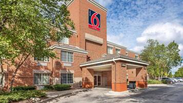 A brick building with a sign indicating '6 suites' and a covered entrance.