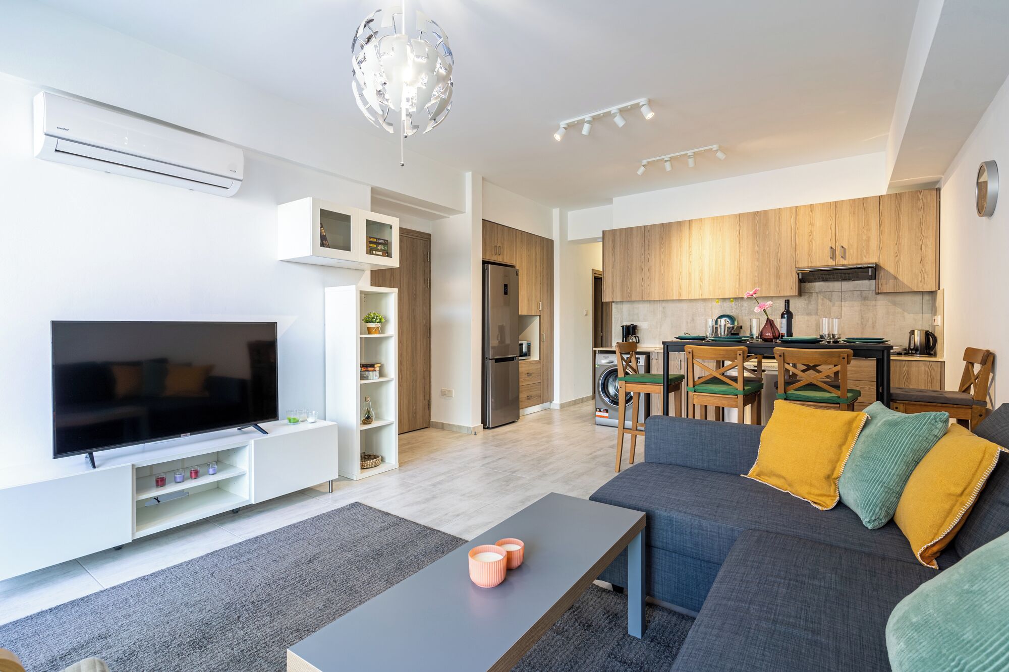 A modern living room with a flat-screen TV, a sofa, and a coffee table.