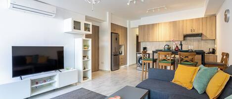 A modern living room with a flat-screen TV, a sofa, and a coffee table.