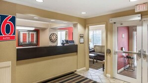 A hotel lobby with a reception desk, a clock, and an exit sign. - 2 Queen Beds | Smoking, Kitchen (Milwaukee WI)