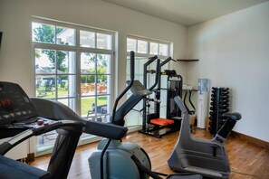 A gym with treadmills, a weight machine, and a water dispenser. - Schwielowsee  Hotel Superior Double Room (Werder)