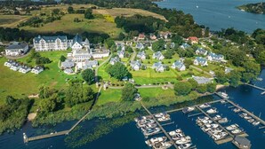 An aerial view of a lakeside property with a large estate, smaller houses, and a marina with boats. - Sunday Schwielowsee Junior Suite Disability Access (Werder)