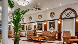 A lobby with a high ceiling, a fan, multiple clocks, and a seating area with sofas and armchairs. - Sunday Schwielowsee Junior Suite Disability Access (Werder)