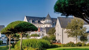 A large, historic building with multiple towers and a well-maintained garden. - Sunday Resort Schwielowsee Suite (Werder)
