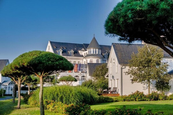 A large, historic building with multiple towers and a well-maintained garden. - Sunday Resort Schwielowsee Suite (Werder)